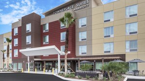 A multi-story hotel with a modern design, featuring a covered entrance and outdoor seating area. - TownePlace Suites by Marriott Titusville Kennedy Space Center (Titusville)