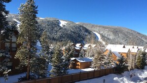 A snow-covered mountain with a ski slope, wooden cabins, and a wooden fence. - Roomy 2BR/2BA in Keystone (Keystone)