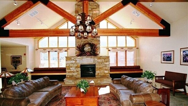 A spacious living room with a stone fireplace, leather sofas, and a wooden coffee table. - Roomy 2BR/2BA in Keystone (Keystone)