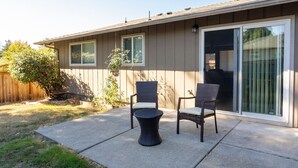 A patio with two wicker chairs and a small round table. - Bright*Private*Stylish 2BR Flat W/ Fenced Yard Near Washington Square (Tigard)