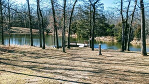 Ein Park am Seeufer mit einer Holzsteg und Bänken.