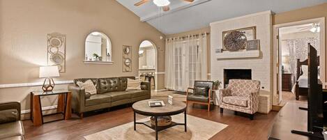 Relax in this inviting living space with a comfortable sofa, armchairs, and a fireplace.