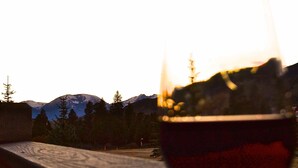 Un verre de vin rouge, avec une vue sur les montagnes en arrière-plan.