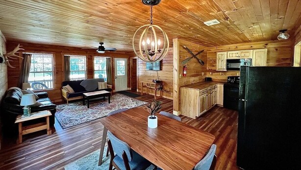 L’intérieur d’une cabane en bois comprend un coin repas, une cuisine et un salon.