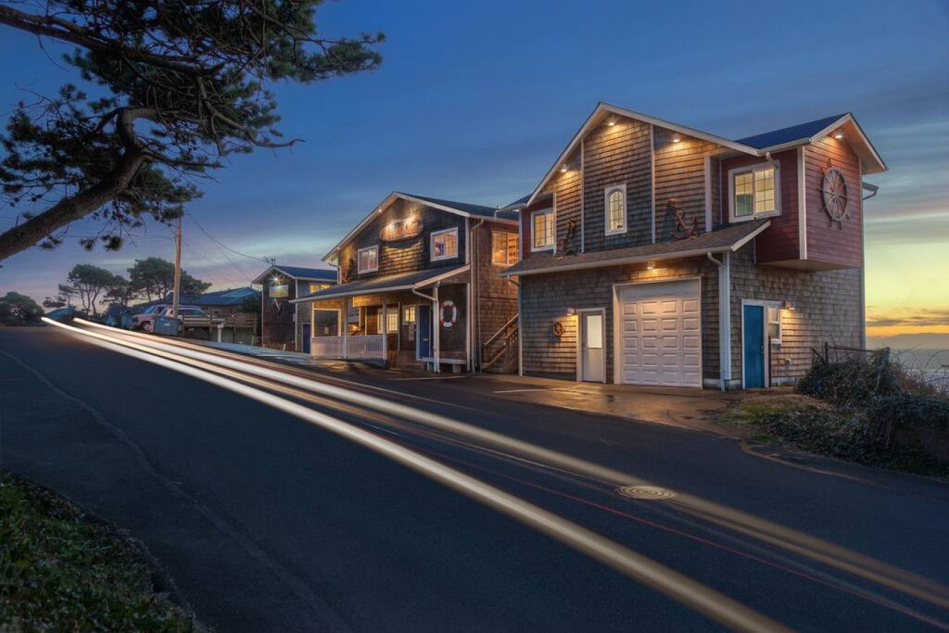 Ein zweistöckiges Haus mit Garage und überdachter Veranda.