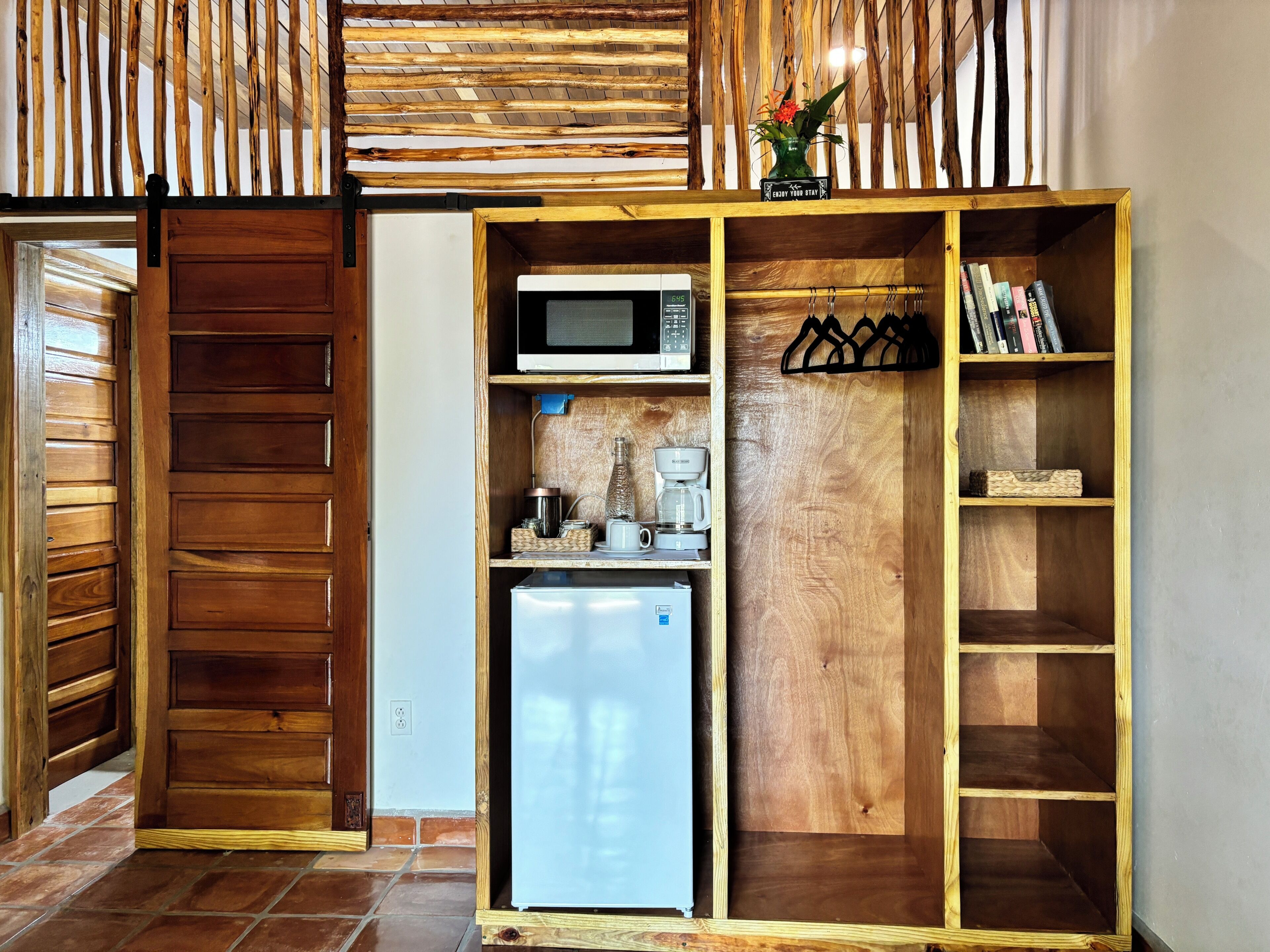Una cocina compacta con microondas, cafetera y refrigerador.