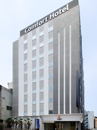 A tall building with a sign reading "Comfort Hotel" at the top.
