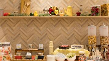 A buffet setup with various food items and serving utensils.