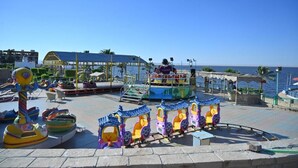A seaside amusement park with colorful rides and a clear view of the ocean.