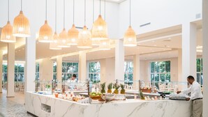 A spacious hotel lobby with a marble reception desk, large pendant lights, and a buffet area. - Senator Puerto Plata - All inclusive (Puerto Plata)