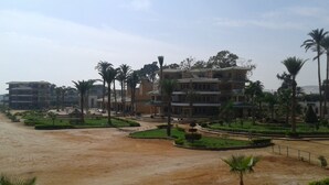 Un hôtel à plusieurs étages doté d’une cour intérieure agrémentée de palmiers et de jardins aménagés.