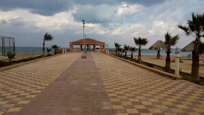 A checkered pathway leading to a covered pavilion with a view of the sea. - Fayed Armed Forces Hotel (Fayed)