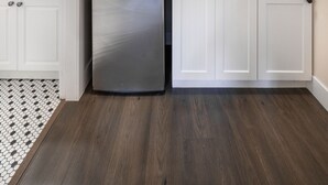 Une cuisine compacte avec des meubles blancs, un four à micro-ondes encastré, un lave-vaisselle et un plan de travail noir.