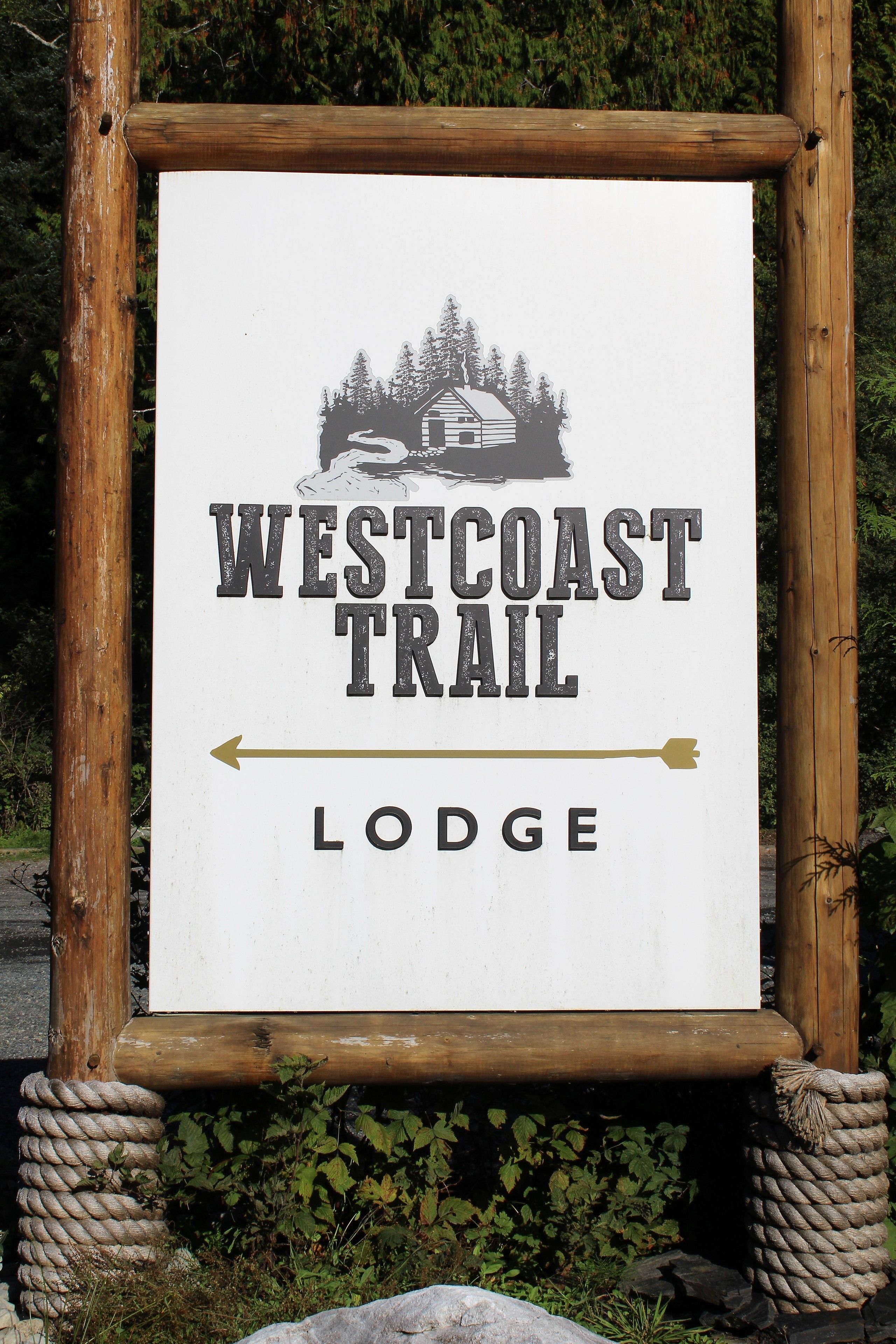 Un panneau indiquant l’emplacement du West Coast Trail Lodge, avec une flèche indiquant la direction.