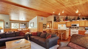 A cozy cabin interior with a wooden ceiling, a dining area, a kitchen with wooden cabinets, and a living room with a sofa and a coffee table. - 5 Modoc-Sunriver, Oregon: Hot Tub, BBQ, WiFi, SHARC Aquatics, Tubing Hill, Mt. Bachelor, Golf, Deschutes River, Tennis, Bike Paths (Sunriver)