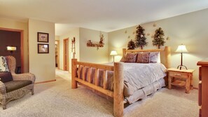 A bedroom with a wooden bed, two bedside tables, a chair, and Christmas decorations. - 5 Modoc-Sunriver, Oregon: Hot Tub, BBQ, WiFi, SHARC Aquatics, Tubing Hill, Mt. Bachelor, Golf, Deschutes River, Tennis, Bike Paths (Sunriver)