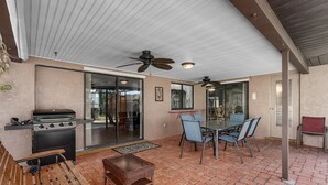 An outdoor patio with a grill, seating, and ceiling fans. - Villa Florida Flair - a Quiet Family Paradise in the Heart of Cape Coral (Cape Coral)