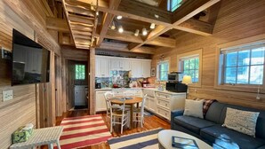 A cozy cabin interior with a kitchen, dining area, and living room. - Vacation at "The Boat House", Private Beach, Near Harbor Springs (Harbor Springs)