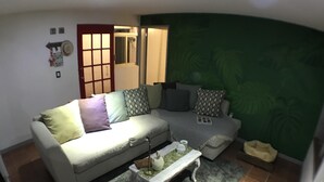 A living room with a sofa, a coffee table, and a pet bed. - Mexican Bohemian Loft (Queretaro)