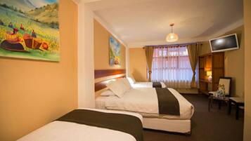 A hotel room with two beds, a television, a painting, and a window with curtains.