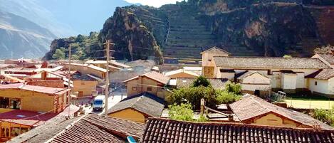 A town with traditional buildings, a mountain backdrop, and a clear sky.