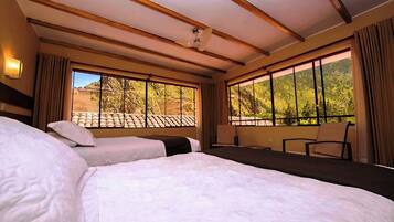 A hotel room with two beds, large windows, a ceiling fan, and a view of the outdoors.