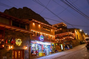 A building with a sign reading "Sol Miranda" and a coffee shop below it. - Sol Miranda Hotel (Ollantaytambo)