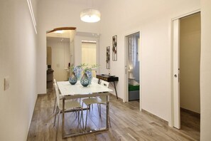 A modern dining area with a white table, metal chairs, and decorative vases. - Meadow Forty-Five Sweet Dreams in Florence (Firenze)