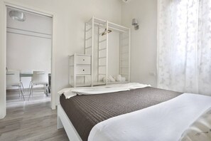 A bedroom with a bed, a wardrobe, a desk, and chairs. - Meadow Forty-Five Sweet Dreams in Florence (Firenze)