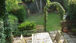 A wooden table with four chairs in a garden setting, surrounded by lush greenery and a well-maintained lawn. - cozy, comfortable, complete, spacious 6-person. holiday home with heated swimming pool (Hastière)