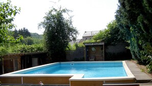 A rectangular swimming pool with a wooden deck and steps leading into it. - cozy, comfortable, complete, spacious 6-person. holiday home with heated swimming pool (Hastière)