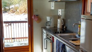 A kitchen with a wooden ceiling, a stainless steel range hood, a coffee maker, and a refrigerator. - Danish Chalet in Gérardmer (Gérardmer)