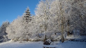 A snow-covered forest with a wooden picnic table. - Danish Chalet in Gérardmer (Gérardmer)
