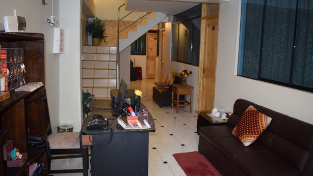 A modern living room with a desk, a sofa, and a staircase leading to another room. - Ruinas View (Ollantaytambo)