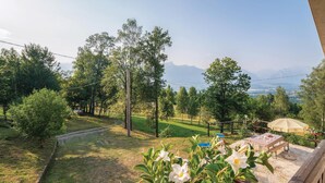 Un jardín con vista a montañas, una cerca de madera y una mesa con un banco.