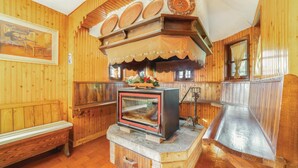 Un interior de madera con chimenea, banca y placas decorativas.