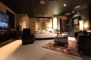 A modern hotel room with a large bed, a seating area with a sofa and armchair, a desk with a computer, and a television. - HOTEL GRASSINO URBAN RESORT UTSUNOMIYA - Adult Only (Utsunomiya)