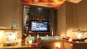 Un área de spa con pantalla digital, velas y flores.