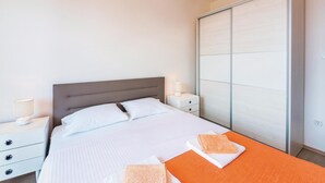 Ein Hotelzimmer mit Bett, Nachttischen, einem Kleiderschrank und einem Badezimmer.