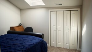 Un dormitorio con cama, escritorio, silla y armario.