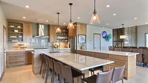 A spacious kitchen with a large island, bar stools, and pendant lighting. - The Luxe Lookout - Private Pool & Breathtaking Beach Views (Port Aransas)
