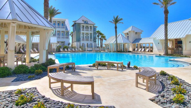 A pool area with lounge chairs, a gazebo, and a large building with a balcony. - The Luxe Lookout - Private Pool & Breathtaking Beach Views (Port Aransas)