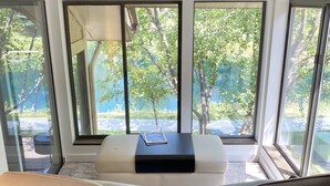 A modern living room with a large window, a sofa, a coffee table, and two chairs. - 2025 Updates - Modern Townhome In Deer Valley With Shuttle Service (Park City)