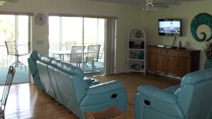 Un salon comprenant un ensemble de canapés, un téléviseur et un ventilateur de plafond.