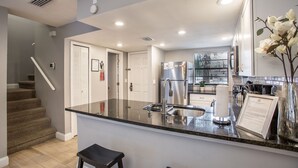 A modern kitchen with a central island, stainless steel appliances, and a view to the dining area.