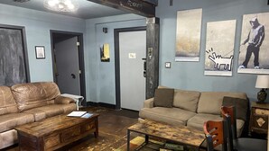 A spacious living room with two leather sofas, a wooden coffee table, and a colorful rug. - Unique two bedroom house in a great location in Colorado springs.   (Colorado Springs)