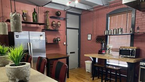 A kitchen with a wooden table, chairs, a refrigerator, a microwave, and various decorative items on shelves. - Unique two bedroom house in a great location in Colorado springs.   (Colorado Springs)