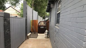 A narrow brick pathway leading to a gated entrance with a fire hydrant. - Unique two bedroom house in a great location in Colorado springs.   (Colorado Springs)