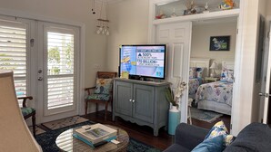 A living room with a television, a sofa, a coffee table, and a chair.