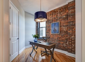 Stylish hallway leads to a dining area with a table and a touch of greenery.